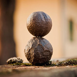 A stone ball sitting on top of another rock.