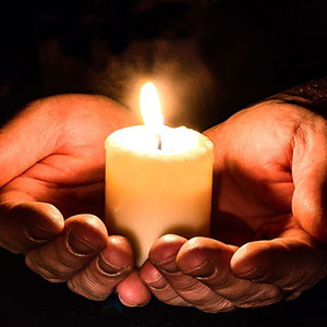 A person holding a candle in their hands