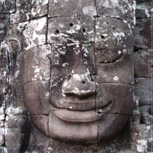 A stone face with many faces on it